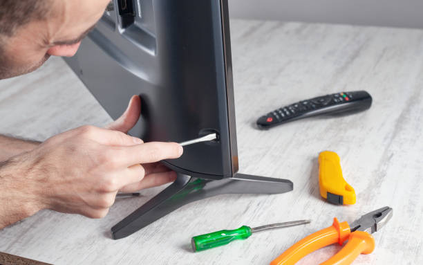 Caucasian engineer repairing Tv at home.